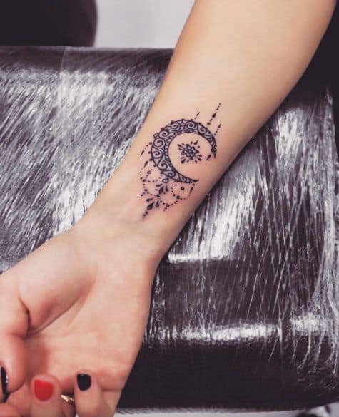 ornate moon wrist tattoos for women